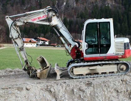 excavator digging hole in yard